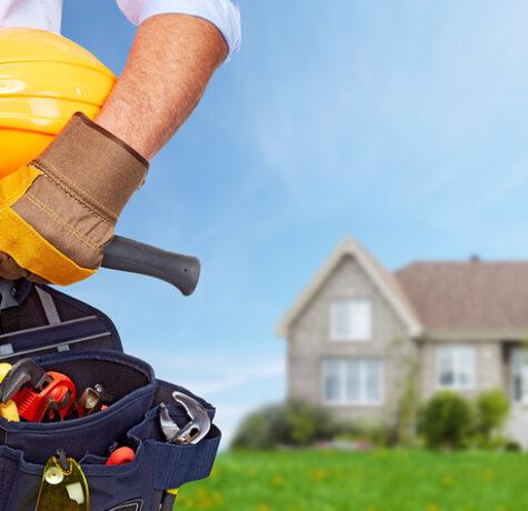 Builder handyman with construction tools. House renovation background.