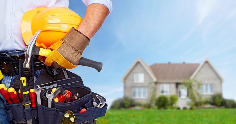 Builder handyman with construction tools. House renovation background.