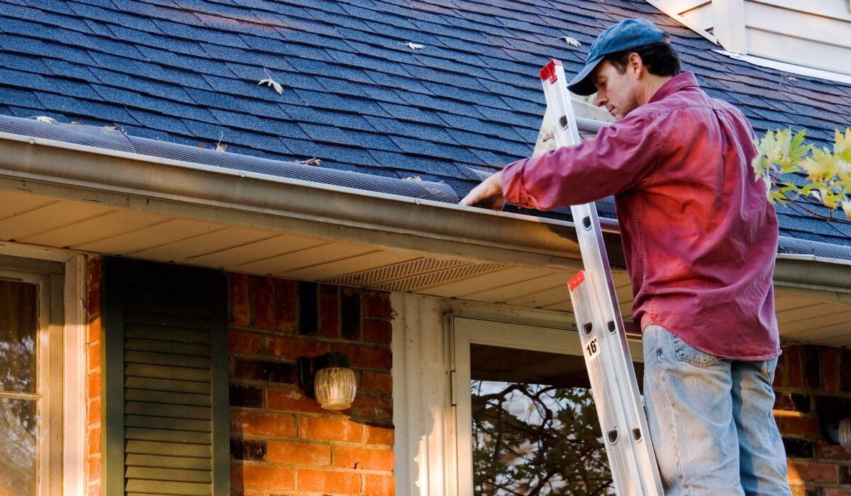 man cleaning gutters