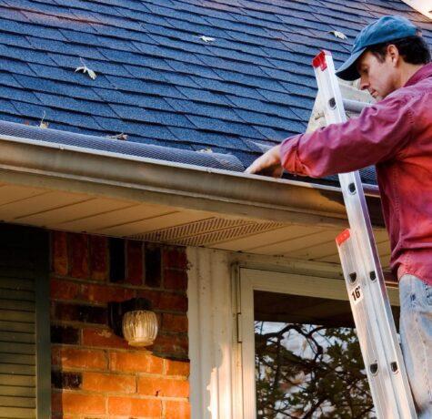 man cleaning gutters